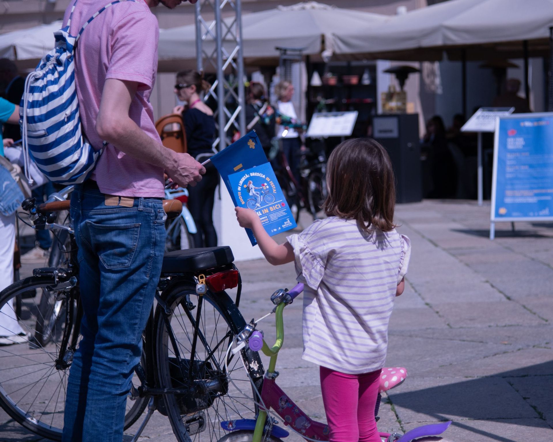 bambina con bandiera blu in bici