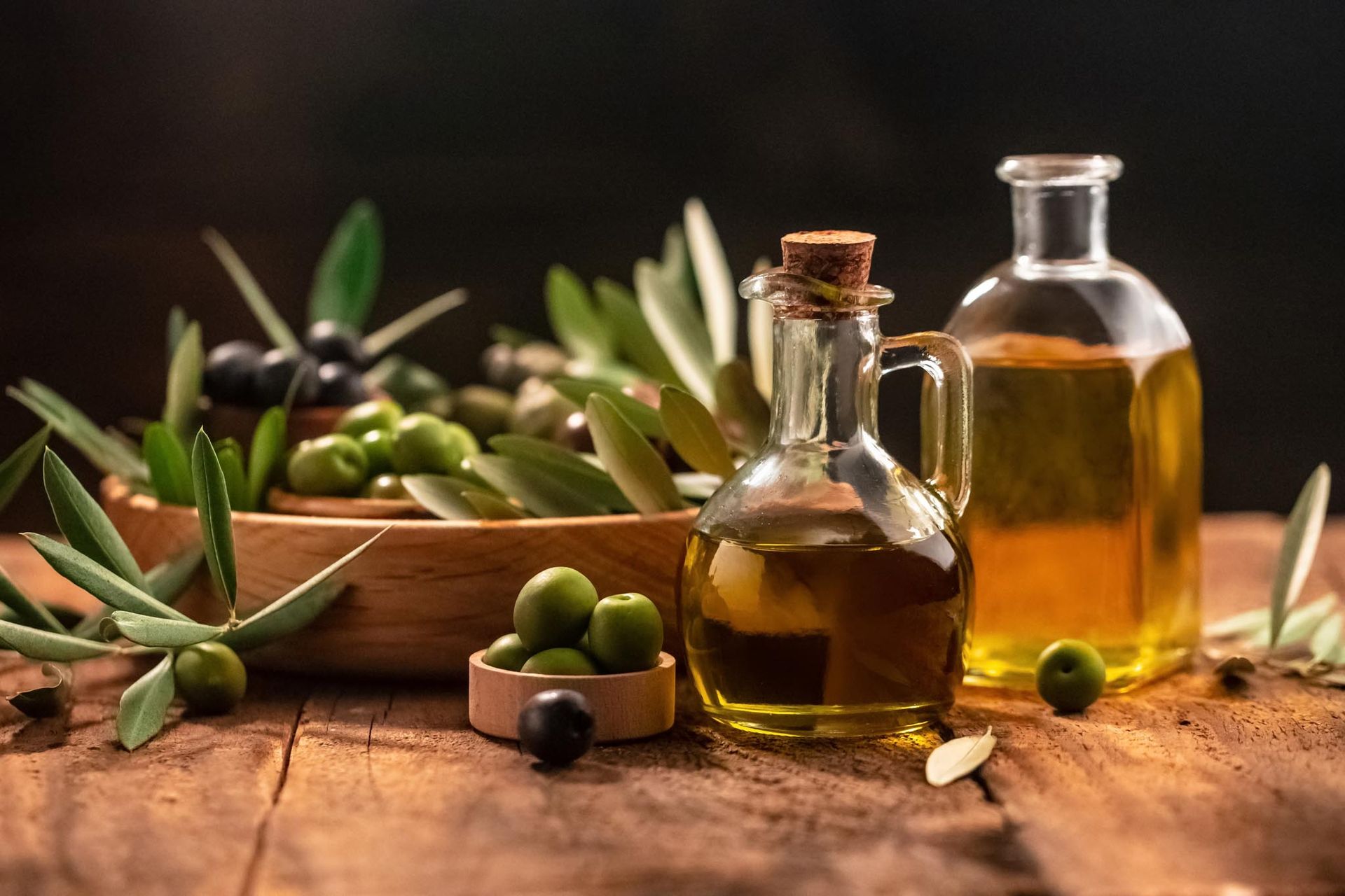 bottiglie di olio del Garda con olive e foglie di ulivo