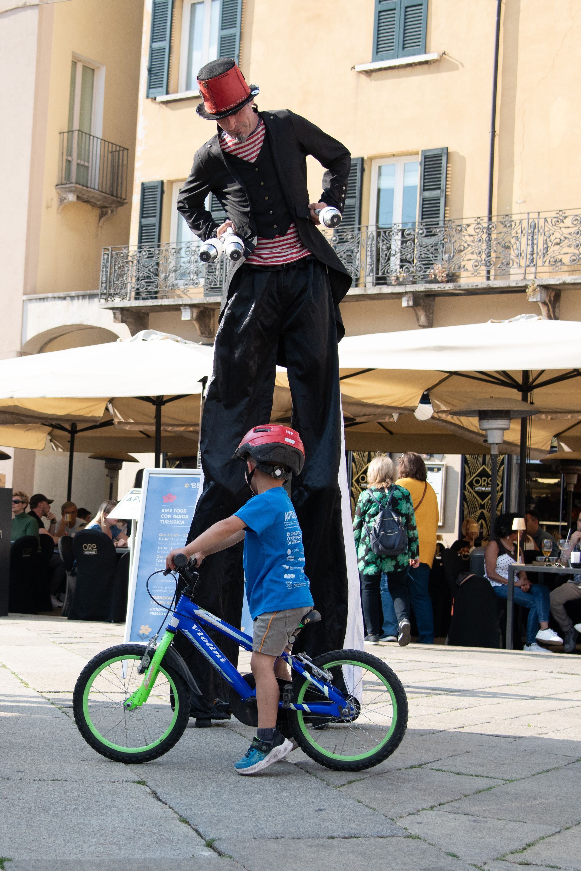 Bambino e giocoliere durante Blu in bici