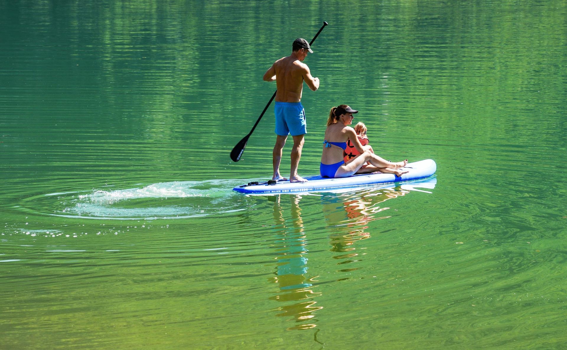 Coppia in paddle board sul Lago d’Idro durante un’escursione estiva