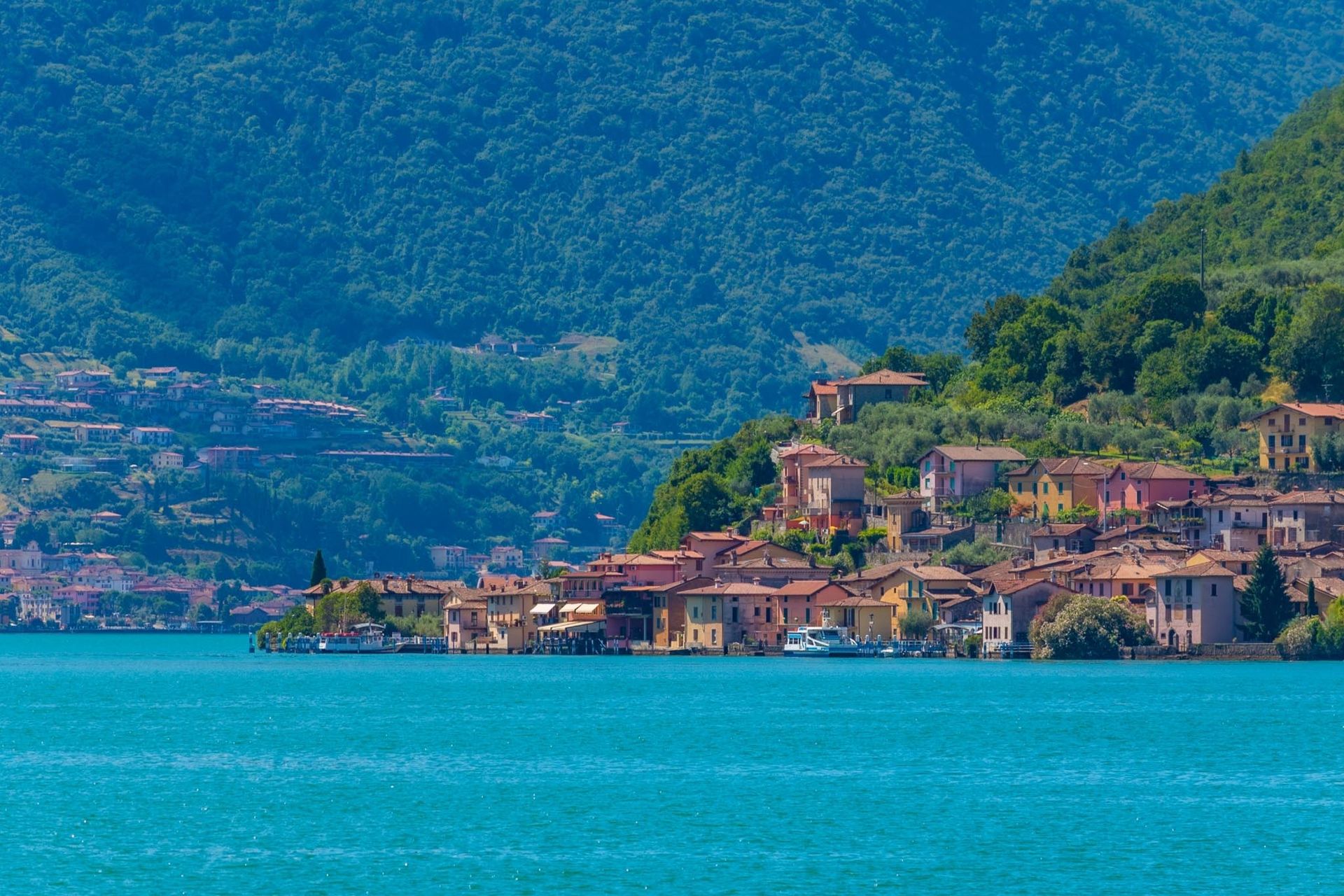 Vello vista dal Lago d’Iseo con le montagne sullo sfondo e case affacciate sull’acqua